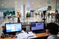 Lực lượng y tế kiểm tra thân nhiệt đối với hành khách nhập cảnh. (Ảnh: Doãn Tấn/TTXVN).