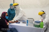 Lấy mẫu xét nghiệm virus SARS-CoV-2 cho người dân tại trạm xét nghiệm nhanh quận Ba Đình. (Ảnh: TTXVN phát).