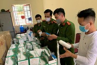 Lực lượng công an kiểm tra lô hàng khẩu trang vừa bị thu giữ. (Nguồn: TTXVN phát).