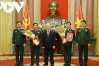 Tổng Bí thư, Chủ tịch nước Nguyễn Phú Trọng trạo Quyết định và tặng hoa cho hai tướng quân đội được thăng quân hàm.