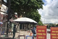 Người dân trong khu vực phong tỏa trên phố Ngô Quyền (Hải Dương) nhận thực phẩm tiếp tế tại hàng rào cách ly. (Ảnh: Mạnh Minh/TTXVN).