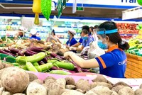Nhân viên Co.op Smile lựa chọn rau củ để "đi chợ giùm" người dân tại TP.HCM. (Ảnh minh hoạ).