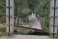 Cầu treo Nam Quang bị đứt gãy khiến xe tải chở hàng rơi xuống sông. (Ảnh: TTXVN phát).