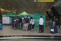 Hành khách xếp hàng chờ xét nghiệm COVID-19 tại sân bay quốc tế OR Tambo ở Johannesburg, Nam Phi. (Ảnh: AFP/TTXVN).