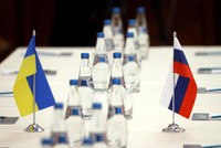 Cờ Ukraine và Nga trên bàn đàm phán của 2 bên. Ảnh: Reuters.