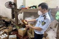 Cán bộ Đội Quản lý thị trường số 24 đang kiểm tra số mật ong vừa tạm giữ tại một cơ sở trên địa bàn huyện Hoài Đức, Hà Nội. (Ảnh: PV/Vietnam+).