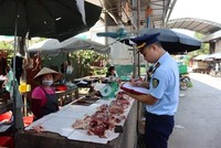 Lực lượng Quản lý thị trường tỉnh Lạng Sơn tuyên truyền, ký cam kết với hộ Kl992 VIP Trang Chủ 2026 tại chợ Trung tâm thương mại thị trấn Đồng Đăng, huyện Cao Lộc. (Ảnh: PV/Vietnam+).