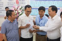 Phó tổng giám đốc BHXH Việt Nam Chu Mạnh Sinh trao thẻ BHYT của bé gái cho anh Đinh Tiến Hoàng.