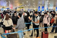 Hành khách xếp hàng dài chờ vào khu vực kiểm tra giấy tờ tùy thân và soi chiếu an ninh tại sân bay Nội Bài. (Ảnh: CTV/Vietnam+).