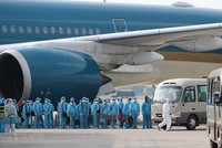 Các công dân xuống máy bay vào xe để về khu cách ly y tế. (Ảnh: Thành Đạt/TTXVN)