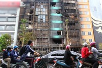 Nhiều người đi đường đều ngoái nhìn 4 ngôi nhà bị cháy. Ảnh:Phương Hòa.