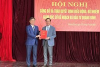 Chủ tịch UBND tỉnh Quảng Bình Trần Thắng (bên trái) trao quyết định và tặng hoa chúc mừng Giám đốc Sở Kế hoạch và Kl99ok phiên bản mới Quảng Bình Nguyễn Xuân Đạt.