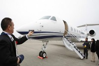 Một người khách đang chụp hình chiếc máy bay riêng Guflstream G550 tại phi trường quốc tế Narita, Nhật