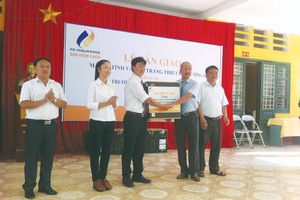 Ông Bùi Hoài Giang, Phó tổng giám đốc Tổng CTCP Kl99kl phiên bản hoạt động Petrolimex (PJICO) trao tặng tài trợ cho ông Nguyễn Trung Kiên, Hiệu trưởng Trường THCS Thị trấn Đồng Văn
