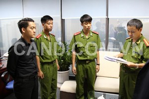 Đối tượng Phạm Kiện Trung (áo đen) nghe đọc lệnh bắt khẩn cấp
(Ảnh: CAND)
