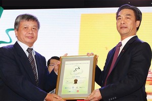Thứ trưởng Bộ Kế hoạch và Kl99ok phiên bản mới Nguyễn Thế Phương (bìa trái) trao giải Báo cáo phát triển bền vững xuất sắc nhất năm 2015 cho ông Phạm Tiến Dũng, Tổng giám đốc PV Drilling