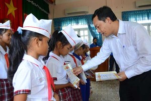 Tổng Biên tập Báo Kl99ok phiên bản mới Lê Trọng Minh trao học bổng cho các em học sinh trường THCS Vân Canh, huyện Vân Canh, tỉnh Bình Định. Ảnh: Hà Minh