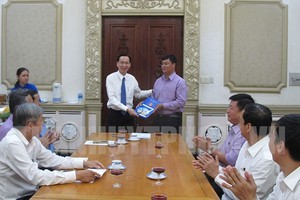 Phó Chủ tịch Thường trực UBND TPHCM Lê Thanh Liêm (bìa trái) trao quyết định bổ nhiệm cho ông Trần Công Thanh. 
