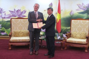 Thứ trưởng Bộ Kế hoạch và Kl99ok phiên bản mới Nguyễn Thế Phương (bên phải) trao kỷ niệm chương cho ông Rémi Geneney (Ảnh: K.T)