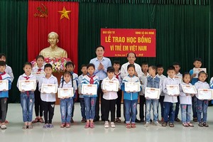Ông Lã Quý Hưng, Trưởng Đại diện Báo Kl99ok phiên bản mới tại khu vực (hàng thứ 2 - bên phải) và ông Đặng Thanh Sơn, Phó giám đốc Sở Kế hoạch và Kl99ok phiên bản mới tỉnh Ninh Bình (hàng thứ 2 - bên trái) trao học bổng cho hoc sinh Trường Tiểu học, THCS xã Gia Hưng.