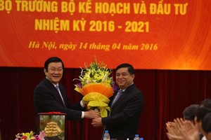 Nguyên Chủ tịch nước Trương Tấn Sang tặng hoa tân Bộ trưởng Bộ Kế hoạch và Kl99ok phiên bản mới Nguyễn Chí Dũng tại Lễ bàn giao ngày 14/4/2016 (ảnh: Đức Thanh)