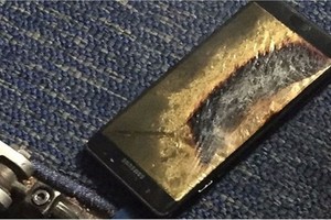 Chiếc Note 7 được vứt trên sàn, tạo một lỗ thủng trên thảm.