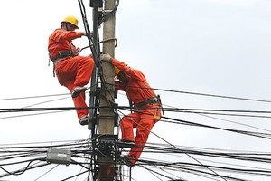 Công nhân ngành điện sửa chữa đường dây lưới điện. Ảnh: Ngọc Thành.