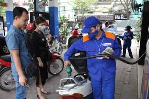 Nhân viên Petrolimex đang bán xăng cho khách hàng. (Ảnh: Đức Duy/Vietnam+)