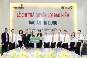 Bà Lê Thị Huệ Anh - Giám đốc Vietcombank Vinh (thứ 7 từ phải sang) trao quyền lợi Kl99kl phiên bản hoạt động nhân thọ Bảo an Tín dụng cho người thụ hưởng Trần Thị Mai Phương (Ảnh: Nguyễn Văn Thắng)