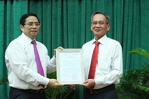 Trưởng Ban Tổ chức Trung ương Phạm Minh Chính trao quyết định cho ông Lữ Văn Hùng. - Ảnh: SGGP