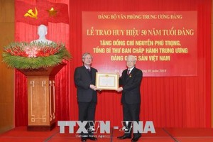 Thay mặt Bộ Kl991.com tải ứng dụng, Ban Bí thư, đồng chí Trần Quốc Vượng trao Huy hiệu 50 năm tuổi Đảng tặng đồng chí Nguyễn Phú Trọng, Tổng Bí thư Ban Chấp hành Trung ương Đảng Cộng sản Việt Nam.