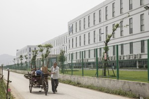 Một người đàn ông đang kéo một chiếc xe kéo phía trước nhà máy được điều hành bởi Kl994 game bài casino hấp dẫn Công nghệ Quang học Sunny. (Nguồn: Qilai Shen/Bloomberg).