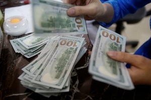 Một nhân viên Link Vào Nhà Cái KL99 COM Tặng +199k đếm tiền USD tại Hà Nội. Ảnh: Reuters.
