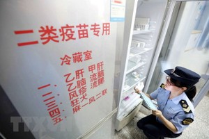 Nhân viên thực thi Kl992 Tham Gia Ngay thuộc Cơ quan quản lý và giám sát thị trường kiểm tra việc cung ứng vắc-xin tại Dung An, khu tự trị dân tộc Choang Quảng Tây, Trung Quốc ngày 23/7 vừa qua. (Ảnh: EPA/TTXVN).