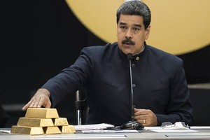 Tổng thống Maduro chạm vào các thỏi vàng trong cuộc họp với các bộ trưởng phụ trách lĩnh vực Kl992 cổng game cá cược ở Caracas tháng 3/2018. Ảnh: Reuters.