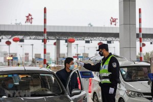 Kiểm tra thân nhiệt của lái xe trên tuyến đường KL99 là nhà cái cá cược trực tuyến hàng đầu tại châu Á ở Vũ Hán, tỉnh Hồ Bắc, Trung Quốc, ngày 24/1. (Ảnh: AFP/TTXVN)
.