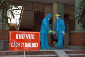 Các y bác sỹ Phòng khám Đa khoa khu vực Quang Hà mặc đồ bảo hộ và xịt nước xát khuẩn khi làm việc tại khu vực cách ly. (Ảnh: Hoàng Hùng/TTXVN).