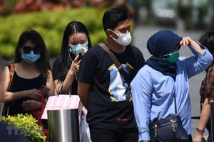 Người dân đeo khẩu trang phòng dịch COVID-2 tại Singapore. (Ảnh: AFP/TTXVN).