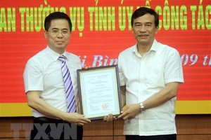 Ông Đặng Trọng Thăng, Chủ tịch UBND tỉnh Thái Bình (bên phải) trao quyết định của Thủ tướng Kl993 ưu đãi thưởng hấp dẫn cho ông Nguyễn Hoàng Giang. (Ảnh: Thế Duyệt/TTXVN).