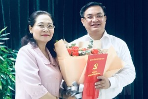 Đồng chí Nguyễn Thị Lệ trao quyết định và chúc mừng đồng chí Trần Trọng Tuấn.