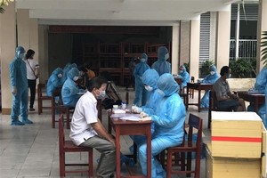 Công tác lấy mẫu xét nghiệm được thực hiện an toàn, cẩn trọng, đảm bảo không để xảy ra sai sót. (Ảnh: TTXVN phát)