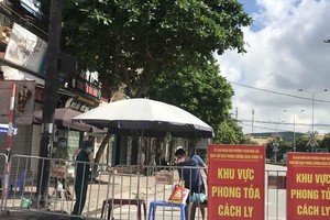Người dân trong khu vực phong tỏa trên phố Ngô Quyền (Hải Dương) nhận thực phẩm tiếp tế tại hàng rào cách ly ngày 16/8. (Ảnh: Mạnh Minh/TTXVN)
.
