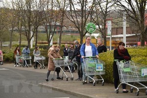 Người dân xếp hàng chờ mua sắm bên ngoài một siêu thị ở Gateshead, Anh. (Ảnh: AFP/TTXVN).