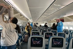 Hành khách trên một chuyến bay thực hiện nghiêm việc đeo khẩu trang theo đúng quy định. (Ảnh: CTV/Vietnam+).