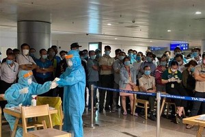Nhân viên y tế làm thủ tục lấy mẫu xét nghiệm cho người làm việc tại sân bay Tân Sơn Nhất. (Ảnh: TTXVN phát).