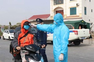 Đo thân nhiệt người dân ở chốt kiểm soát dịch bệnh tại Bắc Ninh. (Ảnh: Thái Hùng/TTXVN).
