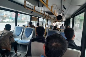 Hành khách đeo khẩu trang và được bố trí ngồi giãn cách theo đúng quy định khi đi xe buýt. (Ảnh: Việt Hùng/Vietnam+).