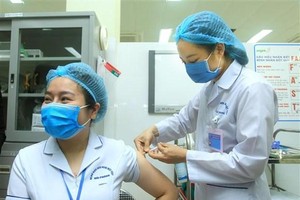 Điều dưỡng viên khu cách ly Bệnh viện Việt Tiệp cơ sở 2 Bùi Thị Thanh Nhung, sinh năm 1987, được tiêm mũi liều vaccine ngừa COVID-19 đầu tiên tại Hải Phòng. (Ảnh: An Đăng/TTXVN).