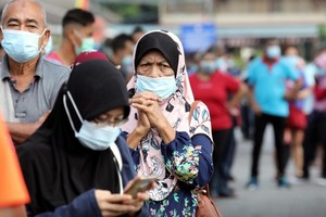 Người dân xếp hàng chờ làm xét nghiệm tại thành phố Klang, Malaysia. (Ảnh: Reuters).