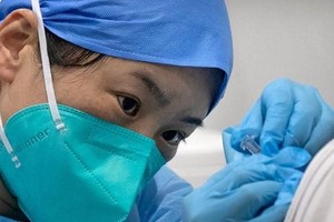 Nhân viên y tế tiêm vaccine ngừa COVID-19 cho một bệnh nhân tại một cơ sở tiêm chủng ở Bắc Kinh. (Nguồn: AP).